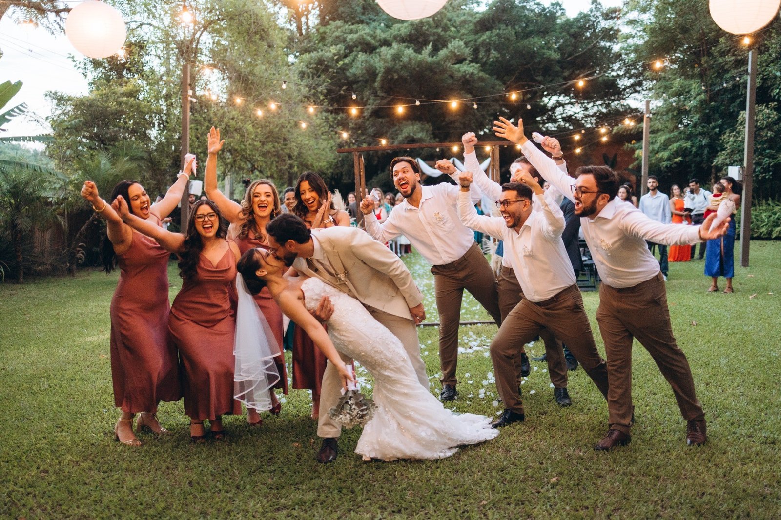 Noivos e padrinhos celebrando em festa ao ar livre